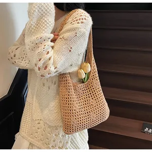 Détail du sac hobo en maille beige montrant l'intérieur spacieux et la texture