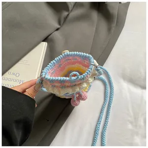 Detail der handgehäkelten Kirschtasche mit Macaron-Farben und Holzknopfverschluss