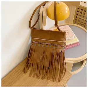Detail of bohemian brown tassel crossbody bag with ethnic weaving and metal coins