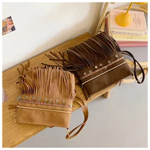 Detail of bohemian fringe crossbody bag with metal studs and woven ethnic trim