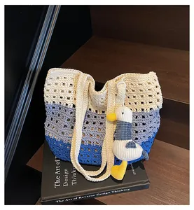Large hand-woven color-block hollow beach bag with a cute knitted duck pendant.