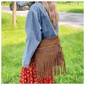 Detail of brown suede crossbody bag with long fringes and ethnic embroidery patterns
