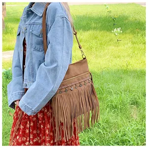 Detail of bohemian fringe crossbody bag with metal pendants and ethnic woven trim