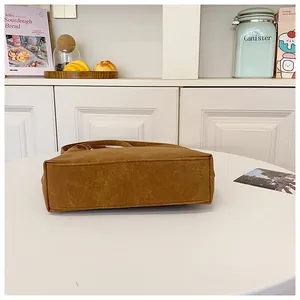 Detail view of the brown matte leather bottom with sturdy stitching on this casual shoulder bag