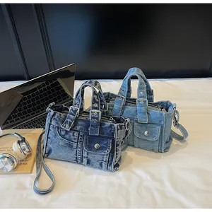 Detail of vintage denim crossbody bags with pocket accents and silver metal rivets