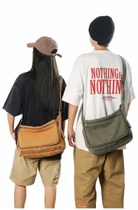 Rear view of models wearing large canvas messenger bags in mustard yellow and olive green