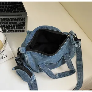 Dettaglio dell'interno della borsa tote in denim blu con piccolo ciondolo portamonete