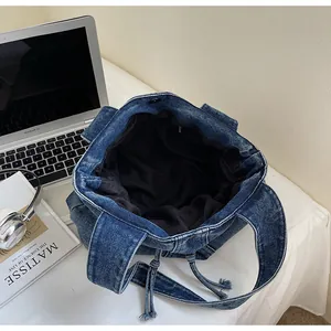 Detailed top view of large blue washed denim tote bag with laptop and office stationery