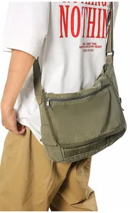 Side view of olive green canvas messenger bag worn by a model for daily commute