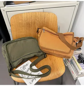 Close-up of vintage canvas messenger bag with flap lid and adjustable strap in army green