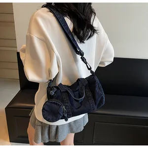 Dettaglio della borsa a secchiello in denim blu con portamonete rotondo su un modello