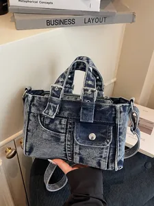 Vintage washed denim handbag with adjustable strap and decorative pocket design