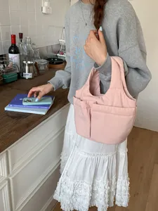 Sac fourre-tout matelassé rose clair avec plusieurs poches avant et un design rembourré