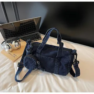 Dettaglio borsa a secchiello in denim blu con tracolla e piccola pochette rotonda