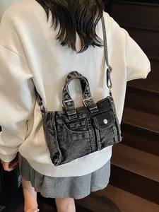 Vintage washed denim shoulder bag in charcoal grey with dual front pockets and metal buckles