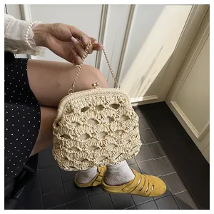 Détail du sac en paille tressé main beige avec chaîne dorée et fermoir vintage