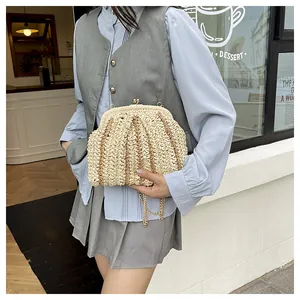 Détail d'un sac en paille tressée à rayures avec fermoir en métal porté par un mannequin