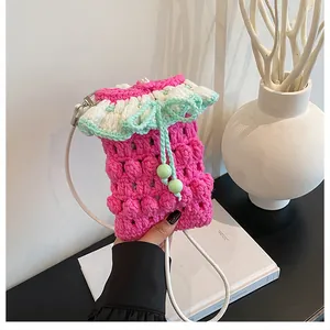 Detail of handmade crochet phone bag with pink yarn and green drawstring closure