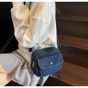 Denim crossbody bag with front flap pocket shown on model during casual daily use