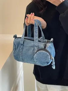 Borsa a secchiello in denim azzurro con mini portamonete indossata da una modella per un look casual
