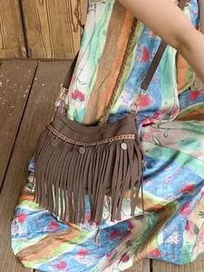 Sac bandoulière en daim bohème avec tissage ethnique et franges sur un mannequin