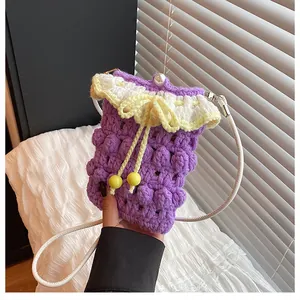 Close-up of purple crochet mini bag featuring bubble stitch, pearl clasp, and yellow bow