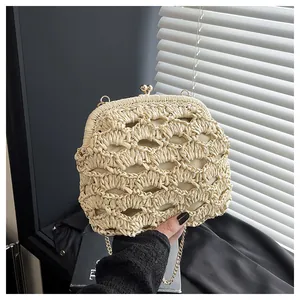 Détail du sac en paille tressée beige avec fermoir boule doré et chaîne en métal