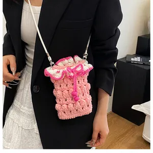 Close-up of pink crochet phone bag featuring ruffle trim and white crossbody strap
