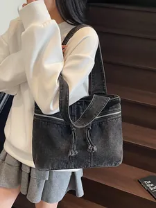 Large gray denim tote bag with silver zippers and tassels for stylish women commuting