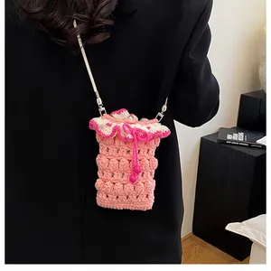 Detail of pink crochet shoulder bag with drawstring and white wavy trim on a black coat