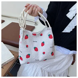 Close-up of strawberry print tote bag with bubble texture fabric and rope handles
