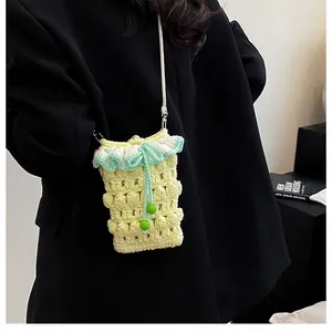 Macro shot of handmade crochet phone bag with yellow bobble knit and green ruffle detail