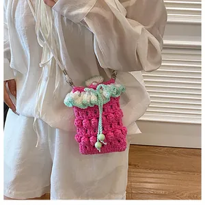 Close-up of handmade crochet phone bag with pink bobble stitch and ruffle detail