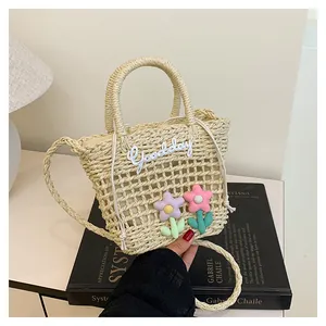 Detail van handgemaakte geweven rieten tas met bloemen en Goodday borduurwerk