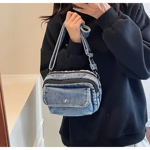 Mirror selfie showing the blue denim crossbody bag with adjustable wide strap and pockets