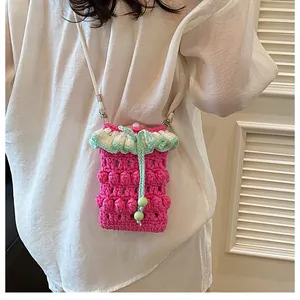 Detail of pink hand-knitted crochet bag with green frills and beaded drawstring