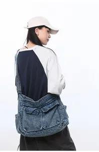 Detail of a large washed denim shoulder bag showing vintage blue texture and utility pockets