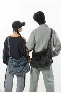 Rear view of models wearing washed denim tote bags with functional pockets in blue and grey