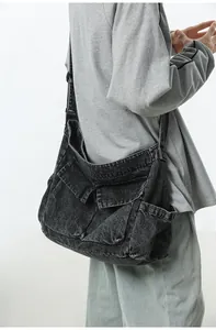 Detail of grey washed denim tote showing cargo pockets and wide shoulder strap texture