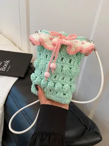 Handmade mint green crochet crossbody bag with pink ruffled trim and drawstring closure