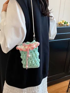 Handmade green crochet crossbody phone bag with pink ruffle trim and slim shoulder strap