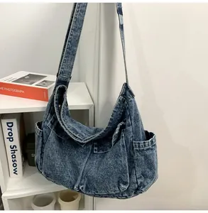 Detail view of large washed denim hobo bag featuring side pocket and textured stitching