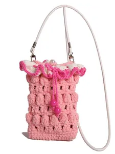 Pink handmade crochet mini crossbody bag with ruffled edge and drawstring closure