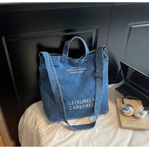 Detail der blauen Denim-Tragetasche mit LEISURELY-Schriftzug und Magnetverschluss