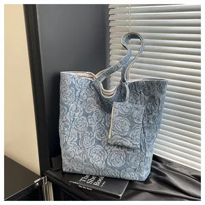 Detalle de tela denim jacquard con rosas azules y borde a rayas en el bolso grande