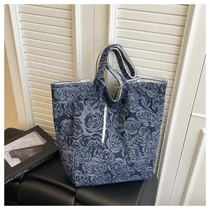 Detalle de bolso tote de jacquard con rosas y una pequeña bolsa con cremallera a juego
