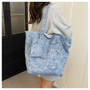 Detalle del bolso tote vaquero azul con monedero a juego y estampado de rosas retro