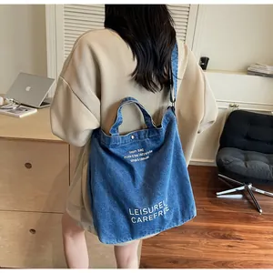 Detailansicht der großen dunkelblauen Denim-Einkaufstasche mit Aufdruck und Tragegurt
