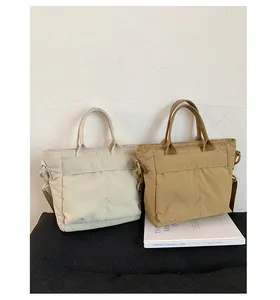 Detail view of canvas bucket bags in cream and khaki with functional front pockets