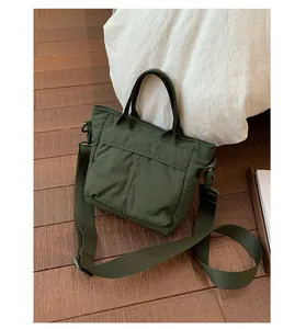 Detail of army green nylon bucket bag with adjustable wide shoulder strap and handle